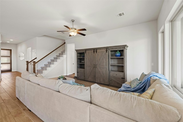 living room with light hardwood / wood-style floors and ceiling fan