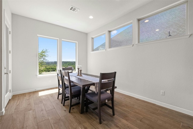 dining room featuring baseboards, visible vents, wood finished floors, and recessed lighting