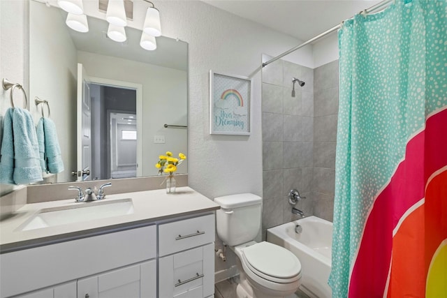 full bath featuring a textured wall, shower / tub combo, vanity, and toilet