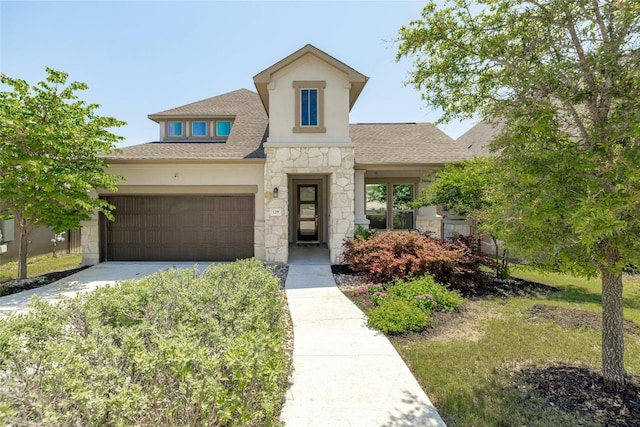 view of front of house featuring a shingled roof, stone siding, driveway, and stucco siding