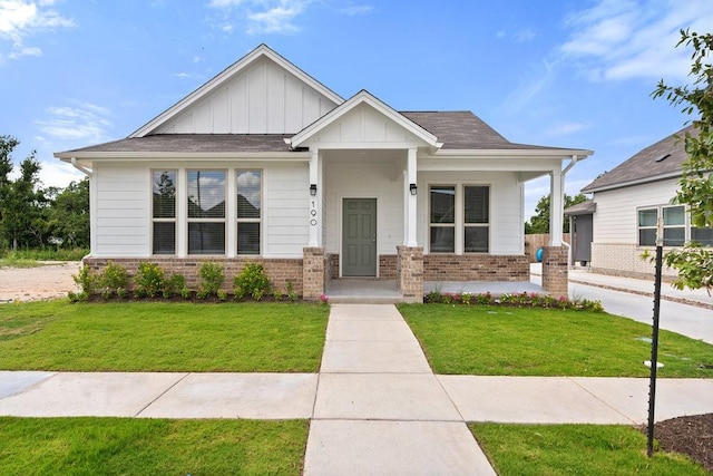 craftsman-style house with a front yard, board and batten siding, and brick siding