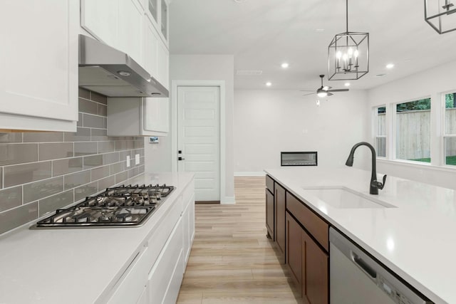 kitchen featuring sink, white cabinetry, dishwasher, pendant lighting, and stainless steel gas stovetop