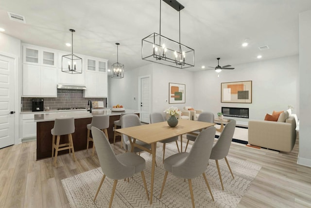 dining area with light hardwood / wood-style flooring and ceiling fan