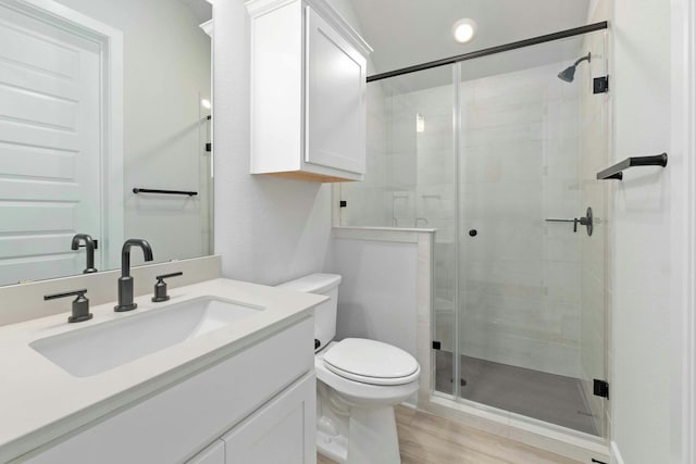 bathroom with vanity, hardwood / wood-style floors, toilet, and walk in shower