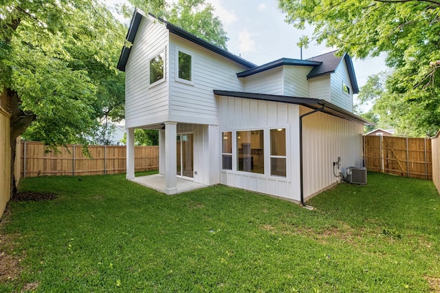 back of property with cooling unit and a lawn