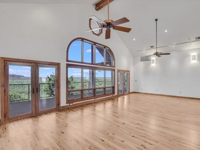 unfurnished living room featuring beamed ceiling, a healthy amount of sunlight, light hardwood / wood-style floors, and high vaulted ceiling