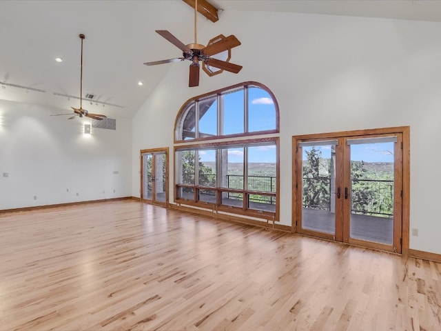 unfurnished living room with french doors, high vaulted ceiling, light wood-type flooring, beamed ceiling, and ceiling fan