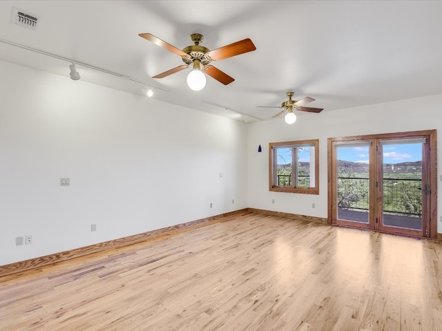 unfurnished room with ceiling fan, track lighting, and light hardwood / wood-style flooring