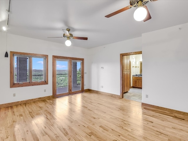 empty room with ceiling fan and light hardwood / wood-style flooring