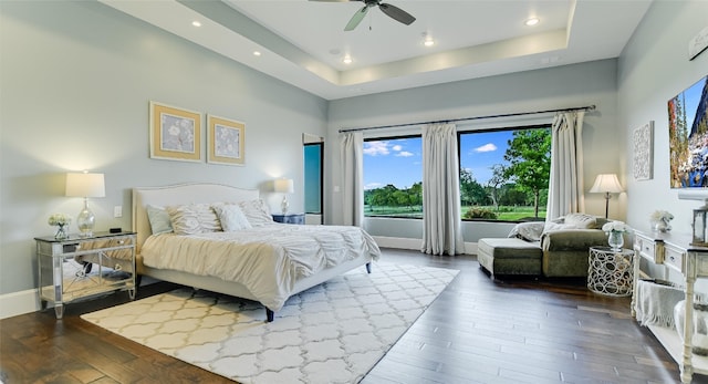 bedroom featuring a tray ceiling, ceiling fan, and hardwood / wood-style floors