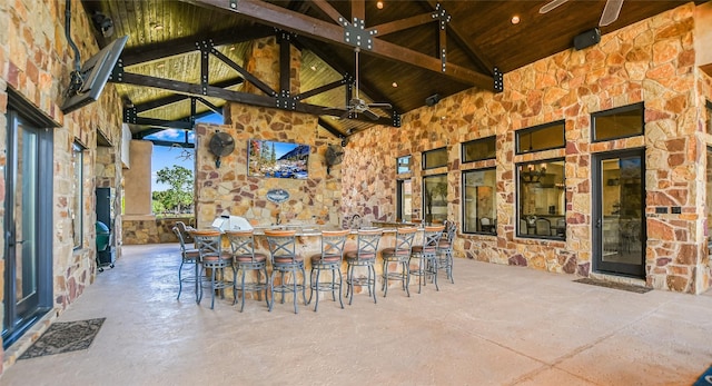 view of patio featuring a bar and ceiling fan