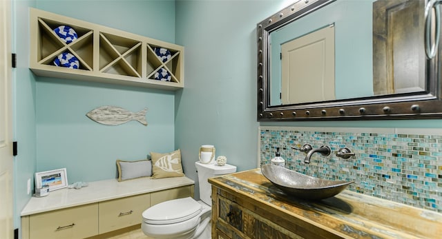 bathroom featuring tasteful backsplash, toilet, and vanity