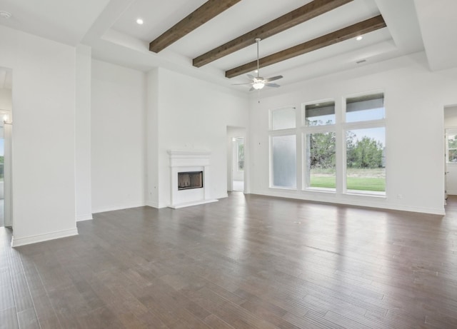 unfurnished living room featuring ceiling fan, beamed ceiling, and dark hardwood / wood-style flooring