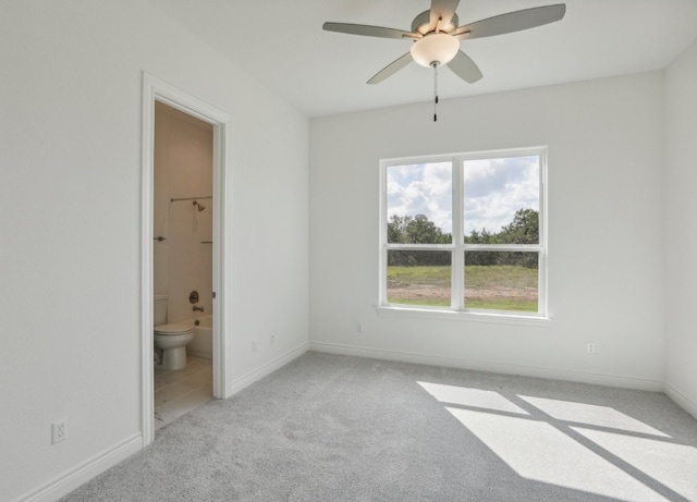 unfurnished bedroom with ceiling fan, light carpet, and ensuite bathroom