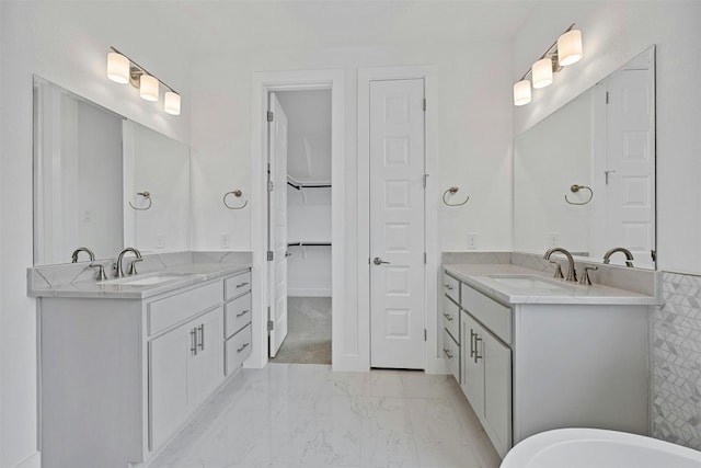 509 Sierra Lisa Cv, Liberty Hill, TX 78642 - full bath with marble look tiles, two vanities, a spacious closet, and a freestanding bath