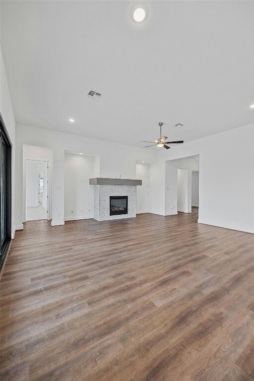 509 Sierra Lisa Cv, Liberty Hill, TX 78642 - unfurnished living room with a tile fireplace, wood finished floors, a ceiling fan, and recessed lighting