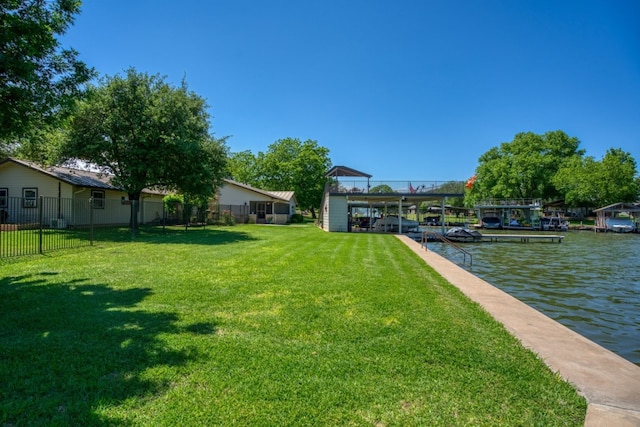 view of yard with a water view and a dock