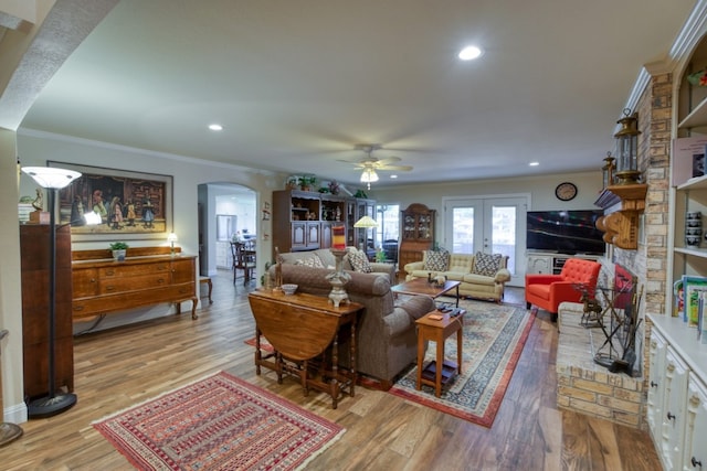 living room with french doors, crown molding, light hardwood / wood-style floors, and ceiling fan