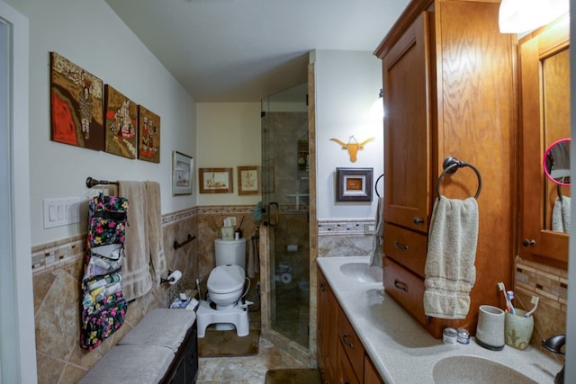 bathroom with walk in shower, vanity with extensive cabinet space, tile floors, tile walls, and toilet