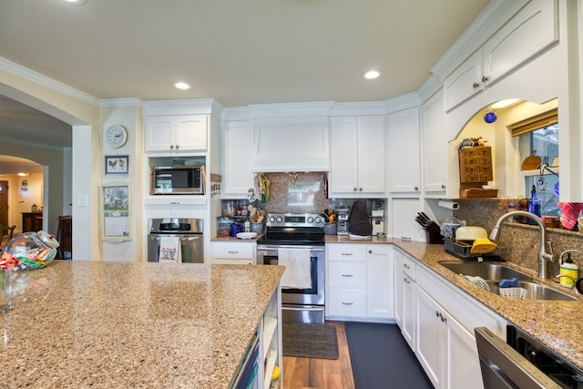 kitchen with white cabinets, sink, stainless steel appliances, and light stone countertops