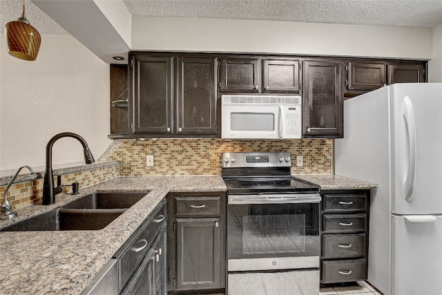 kitchen featuring backsplash, sink, dark brown cabinets, and white appliances