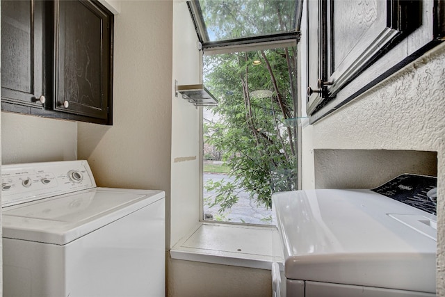 laundry area featuring washing machine and clothes dryer and cabinets