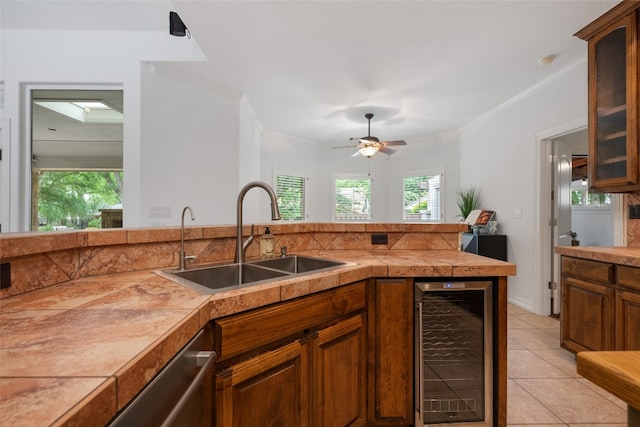 kitchen with ceiling fan, wine cooler, sink, light tile flooring, and ornamental molding