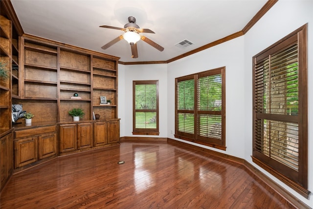 unfurnished office with ceiling fan, dark wood-type flooring, and ornamental molding