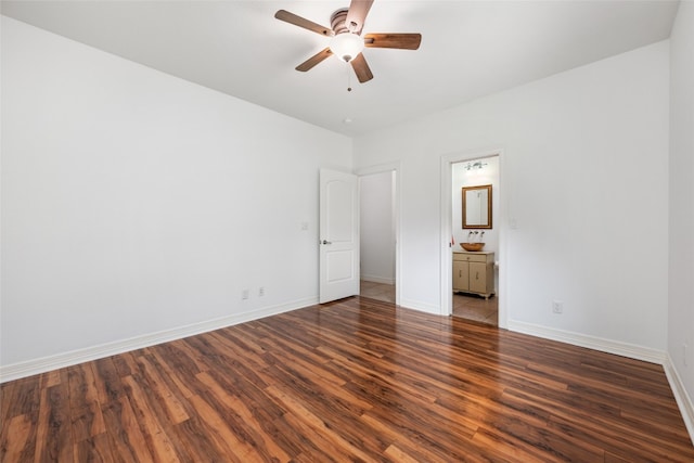 unfurnished bedroom featuring ensuite bath, dark hardwood / wood-style floors, and ceiling fan