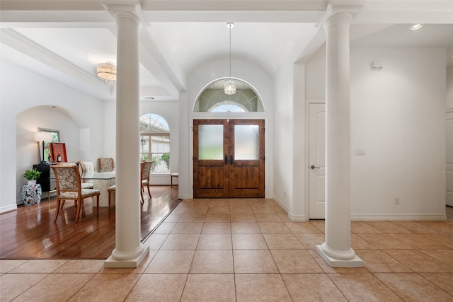 tiled entryway with lofted ceiling and ornate columns