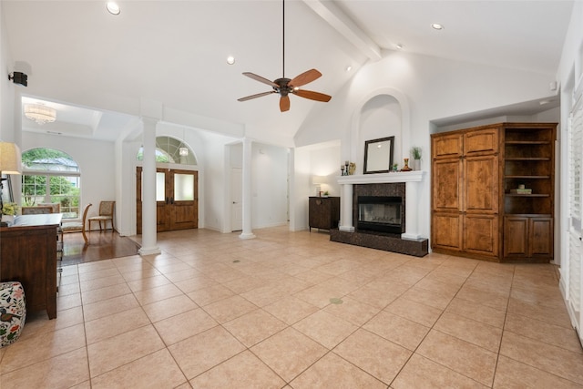 tiled living room with high vaulted ceiling, decorative columns, a fireplace, beam ceiling, and ceiling fan