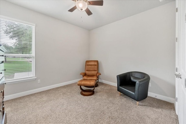 living area with light carpet, ceiling fan, and baseboards