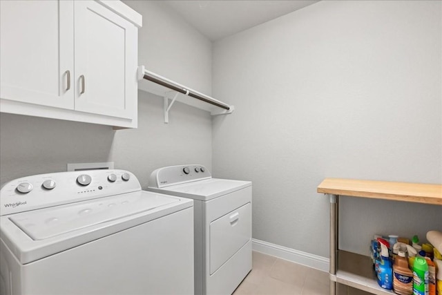 washroom with cabinet space, independent washer and dryer, baseboards, and light tile patterned flooring