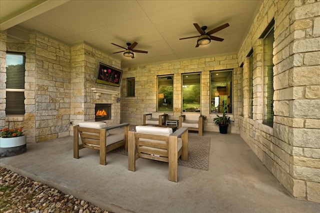 view of patio featuring a ceiling fan and an outdoor living space with a fireplace