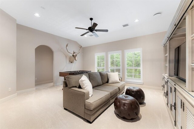 carpeted living room with ceiling fan and lofted ceiling