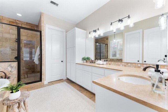 bathroom featuring tile patterned flooring, vanity, and a shower with shower door