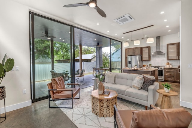 living room featuring ceiling fan, concrete floors, and expansive windows