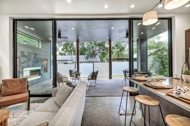 interior space with concrete floors, ceiling fan, and expansive windows