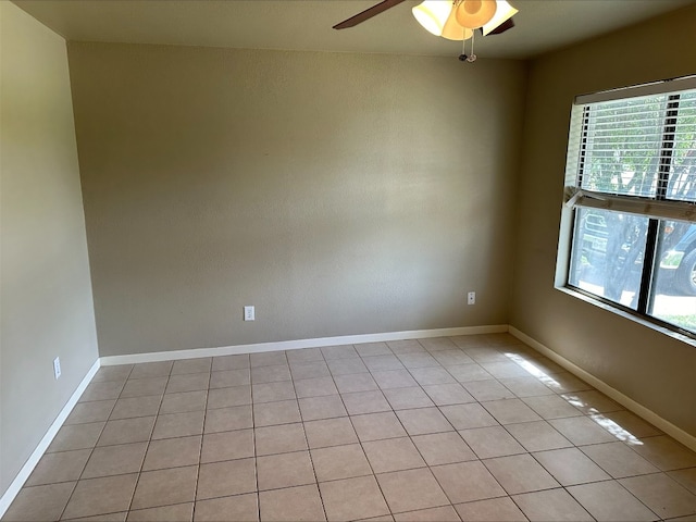 tiled empty room featuring plenty of natural light and ceiling fan