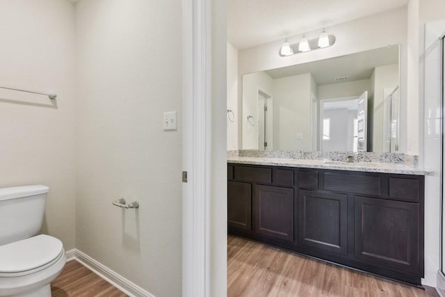 bathroom featuring hardwood / wood-style flooring, vanity, and toilet