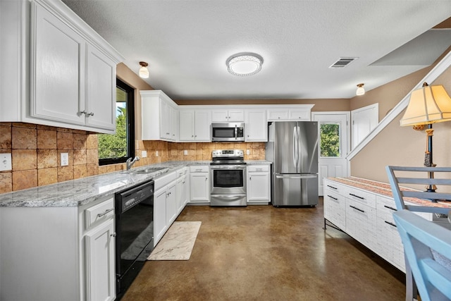 kitchen featuring white cabinets, appliances with stainless steel finishes, and plenty of natural light