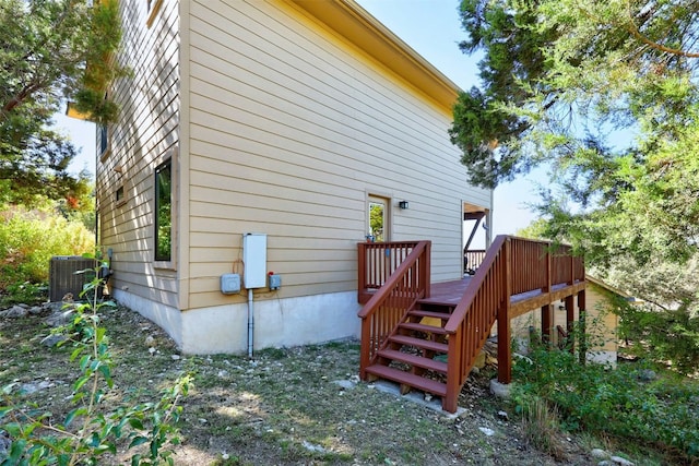 view of side of property featuring a deck and central AC unit