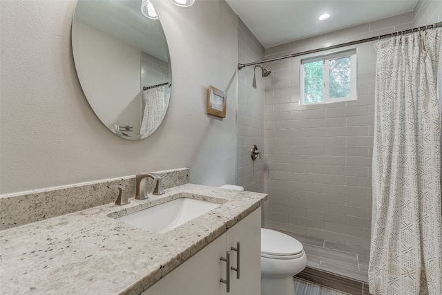 bathroom with curtained shower, vanity, and toilet