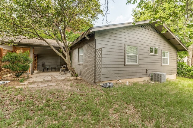 back of property featuring a yard, central AC unit, and a patio