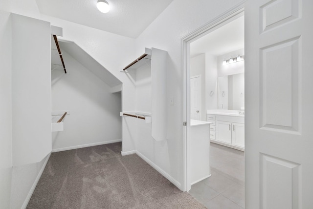 walk in closet with tile floors and sink