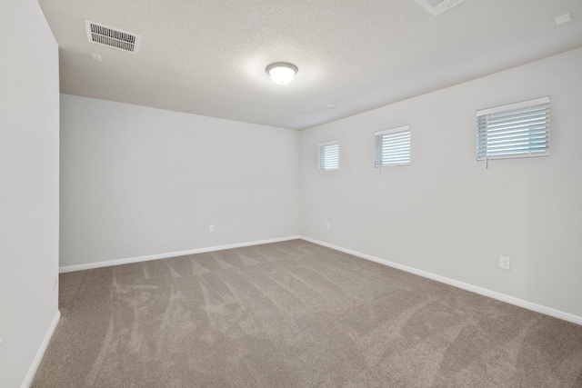 empty room featuring a textured ceiling and carpet floors