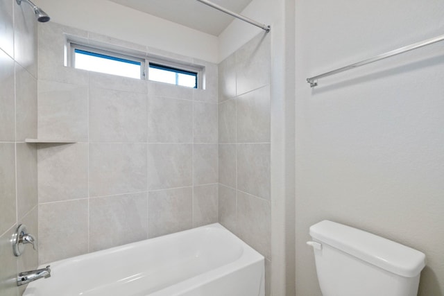 bathroom with tiled shower / bath combo and toilet