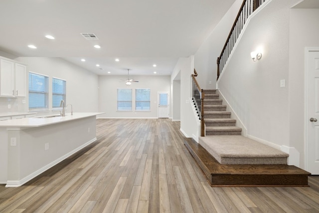 interior space with sink, light hardwood / wood-style flooring, and ceiling fan