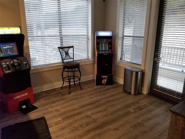 living area with a wealth of natural light and dark hardwood / wood-style flooring