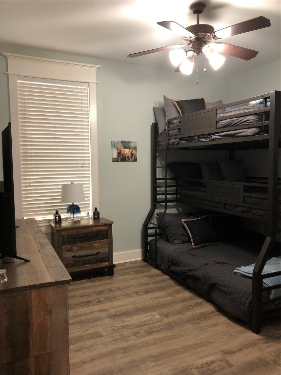 bedroom with dark hardwood / wood-style flooring and ceiling fan